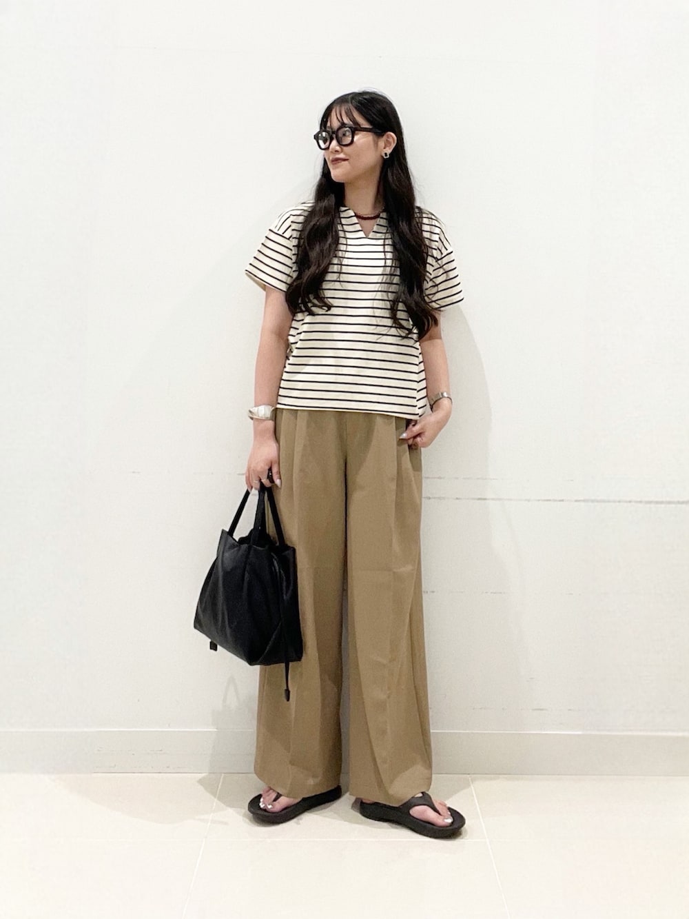 ホワイト系のTシャツ/カットソー、ベージュ系のその他パンツ、ブラック系のショルダーバッグを着用したレディースの夏コーディネートの2枚目の写真