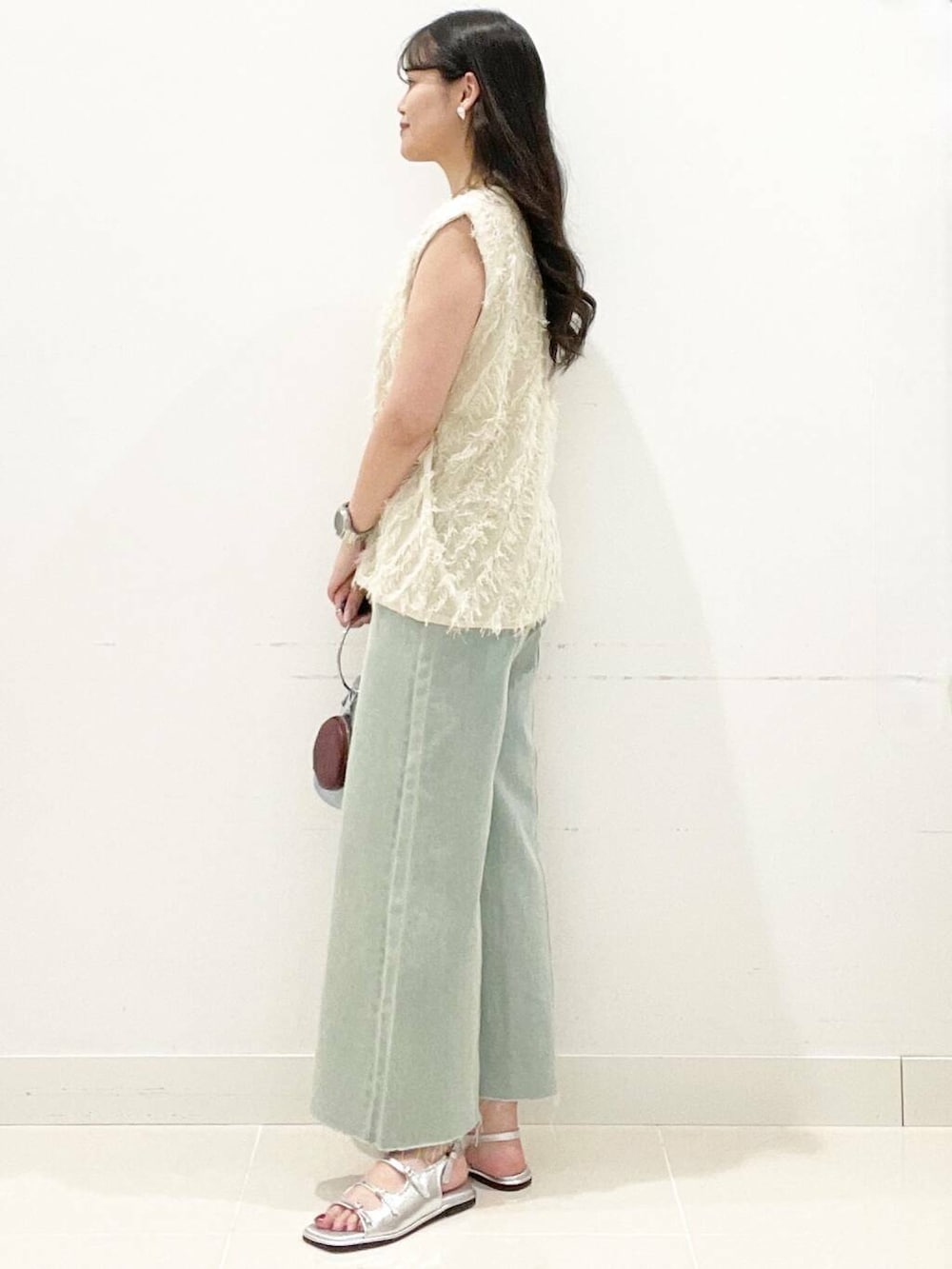 ブルー系のハンドバッグ、ホワイト系のキャミソール、シルバー系のサンダルを着用したレディースの夏コーディネートの5枚目の写真