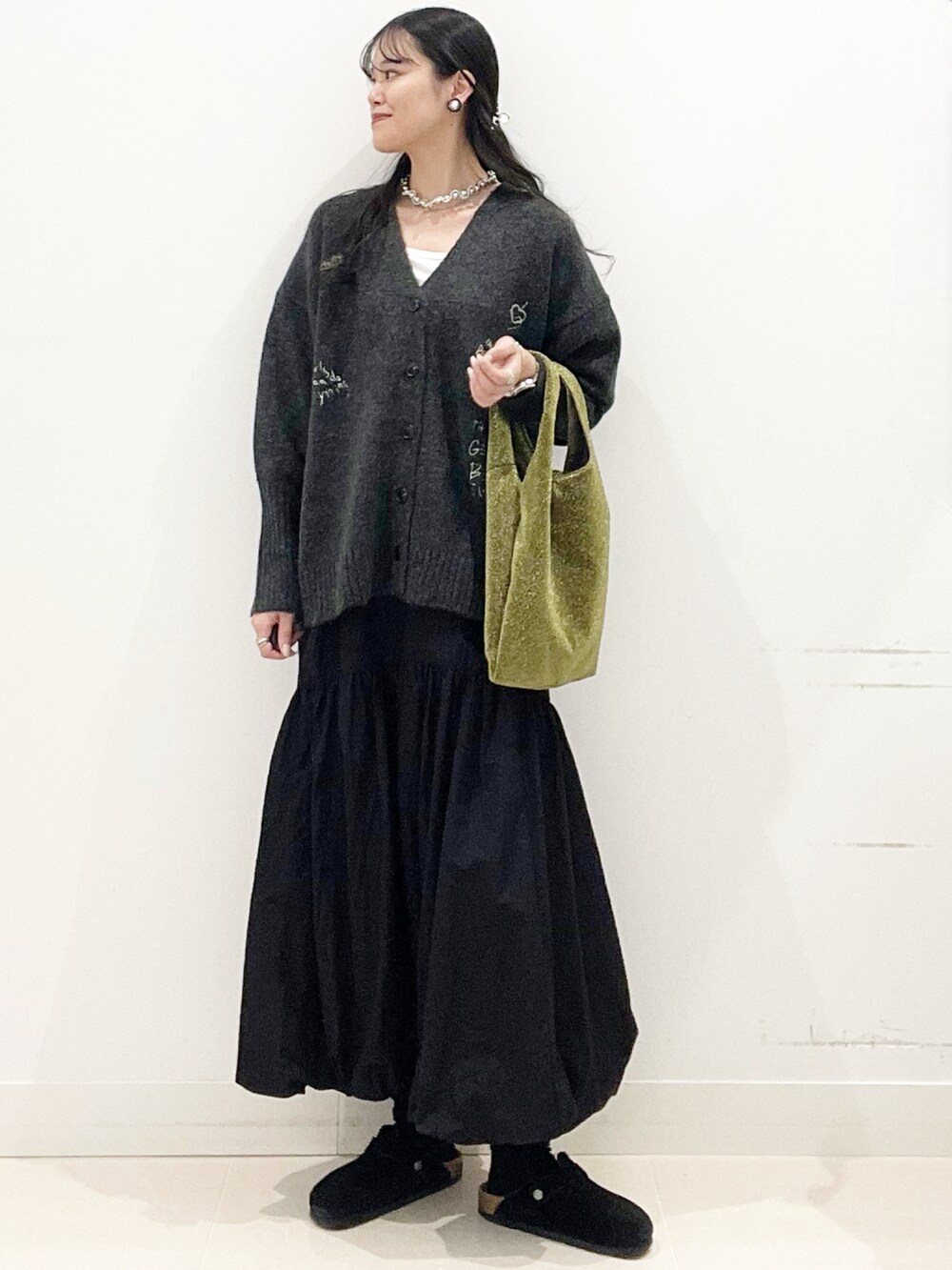 ホワイト系のTシャツ/カットソー、ゴールド系のトートバッグ、ブラック系のスカートを着用したレディースの秋コーディネートの2枚目の写真