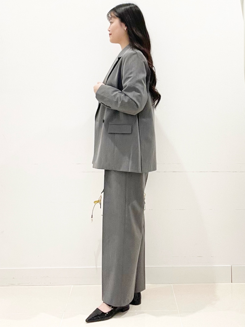 ブラック系のパンプス、グレー系のスラックス、ホワイト系のハンドバッグを着用したレディースの冬コーディネートの5枚目の写真