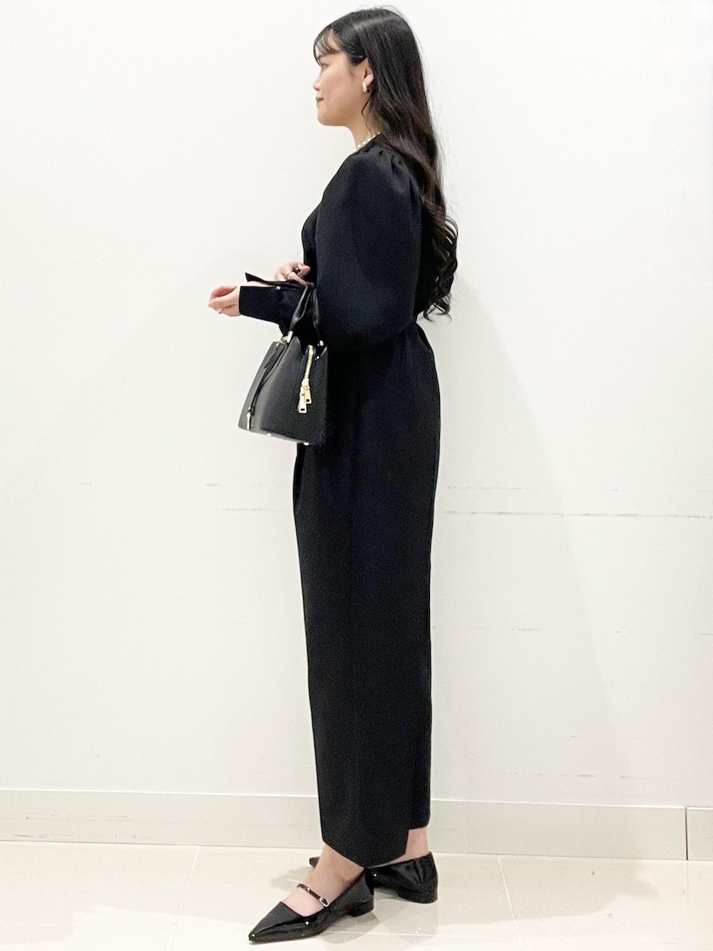 ブラック系のパンプス、ブラック系のハンドバッグ、ブラック系のつなぎ/オールインワンを着用したレディースの冬コーディネートの5枚目の写真