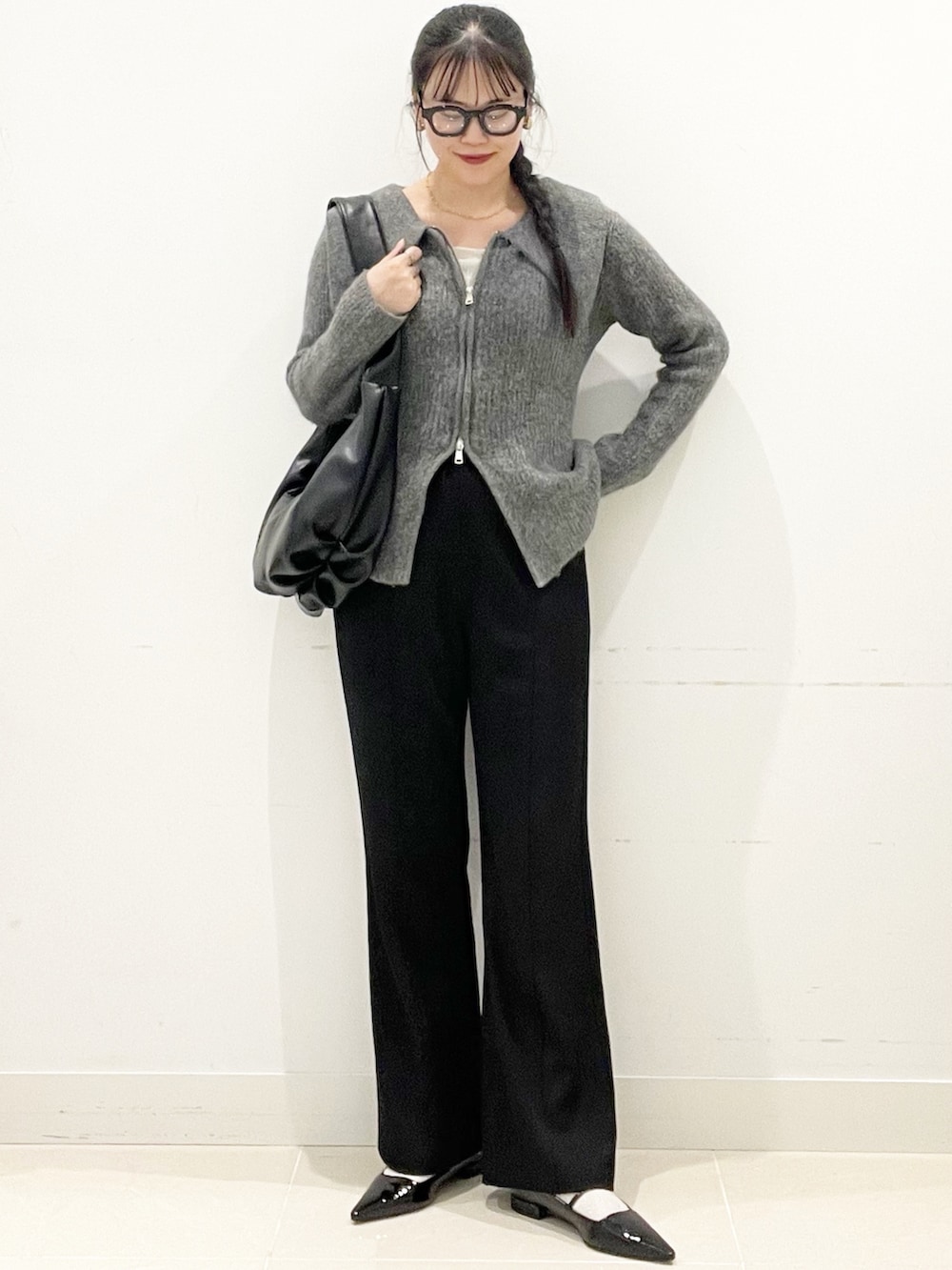 グレー系のカーディガン/ボレロ、ブラック系のパンプス、ホワイト系のTシャツ/カットソーを着用したレディースの冬コーディネートの4枚目の写真