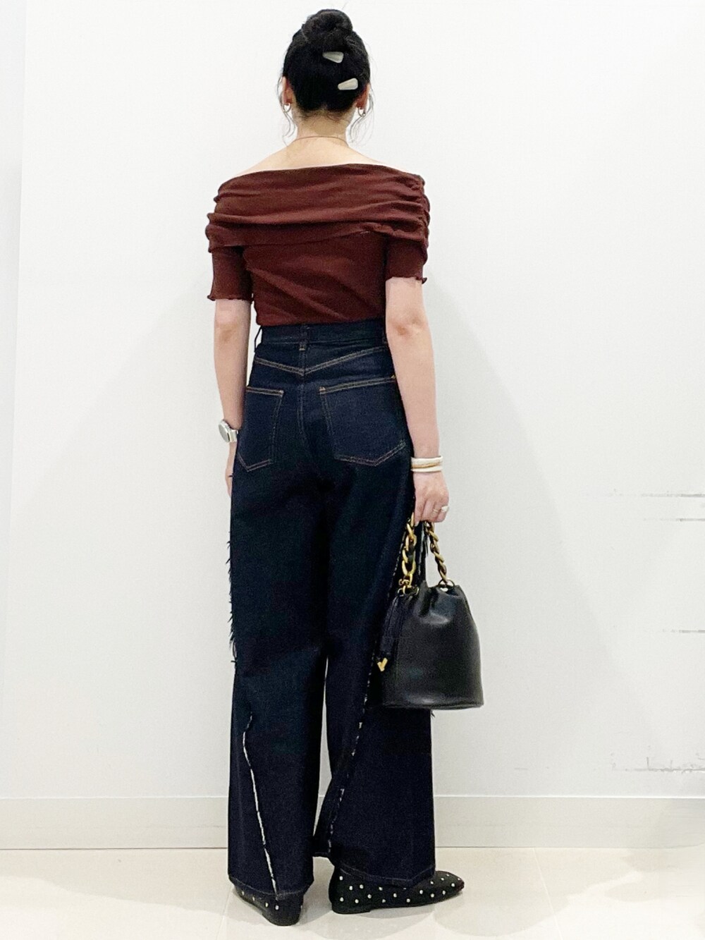 ブルー系のデニムパンツ、ブラック系のショルダーバッグ、ブラック系のパンプスを着用したレディースの夏コーディネートの8枚目の写真