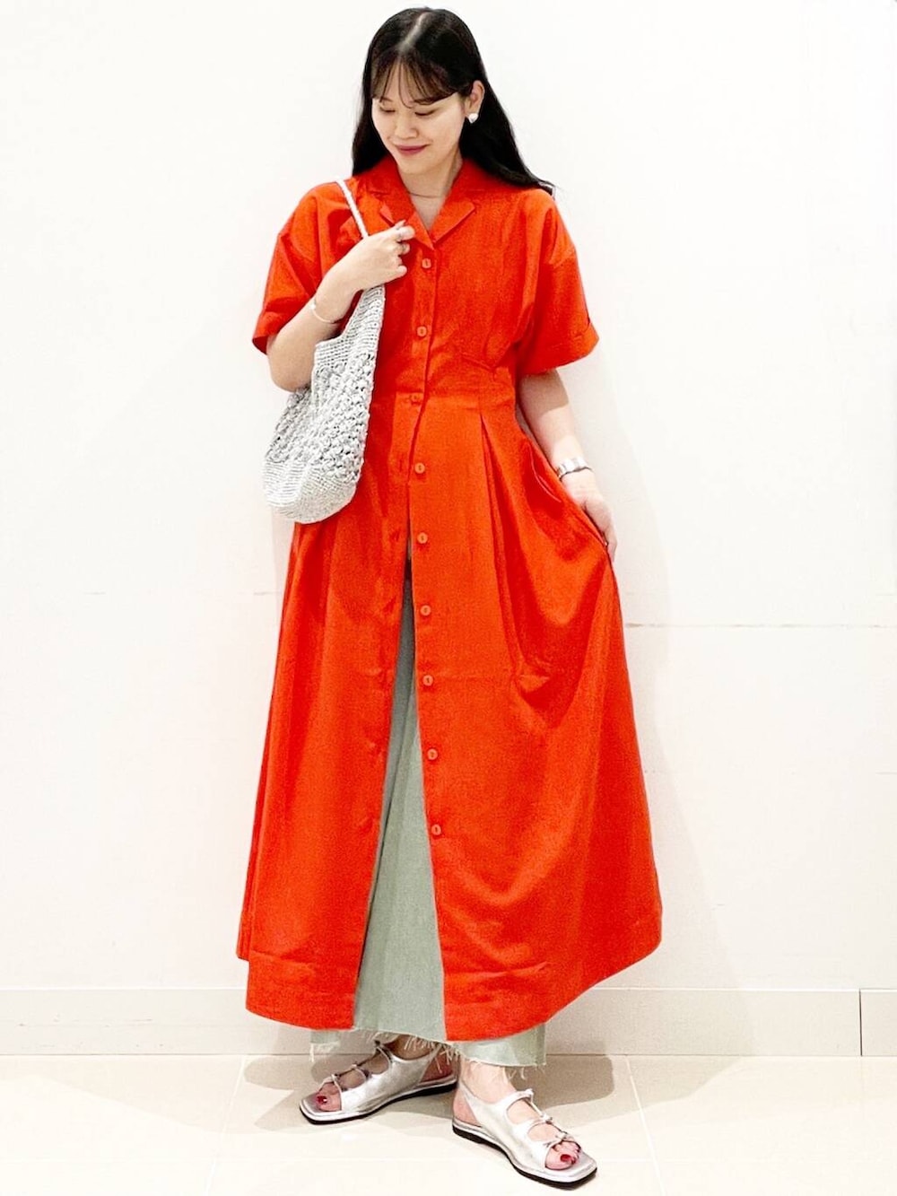 シルバー系のハンドバッグ、ホワイト系のキャミソール、レッド系のワンピースを着用したレディースの夏コーディネートの4枚目の写真