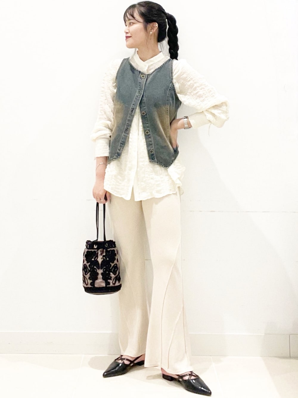 ブラウン系のハンドバッグ、ベージュ系のその他パンツ、ブラック系のその他シューズを着用したレディースの秋コーディネートの3枚目の写真