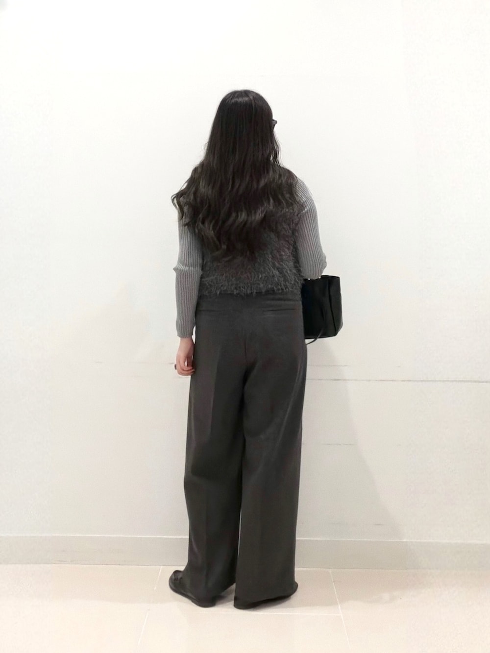 グレー系のその他パンツ、ブラック系のトートバッグ、グレー系のニット/セーターを着用したレディースの秋コーディネートの3枚目の写真