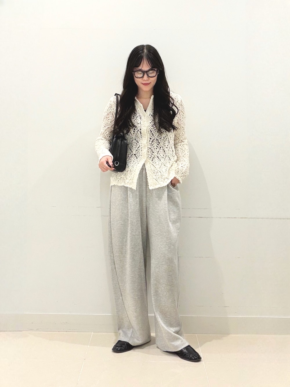 グレー系のその他パンツ、ホワイト系のニット/セーター、ブラック系のボストンバッグを着用したレディースの秋コーディネートの6枚目の写真