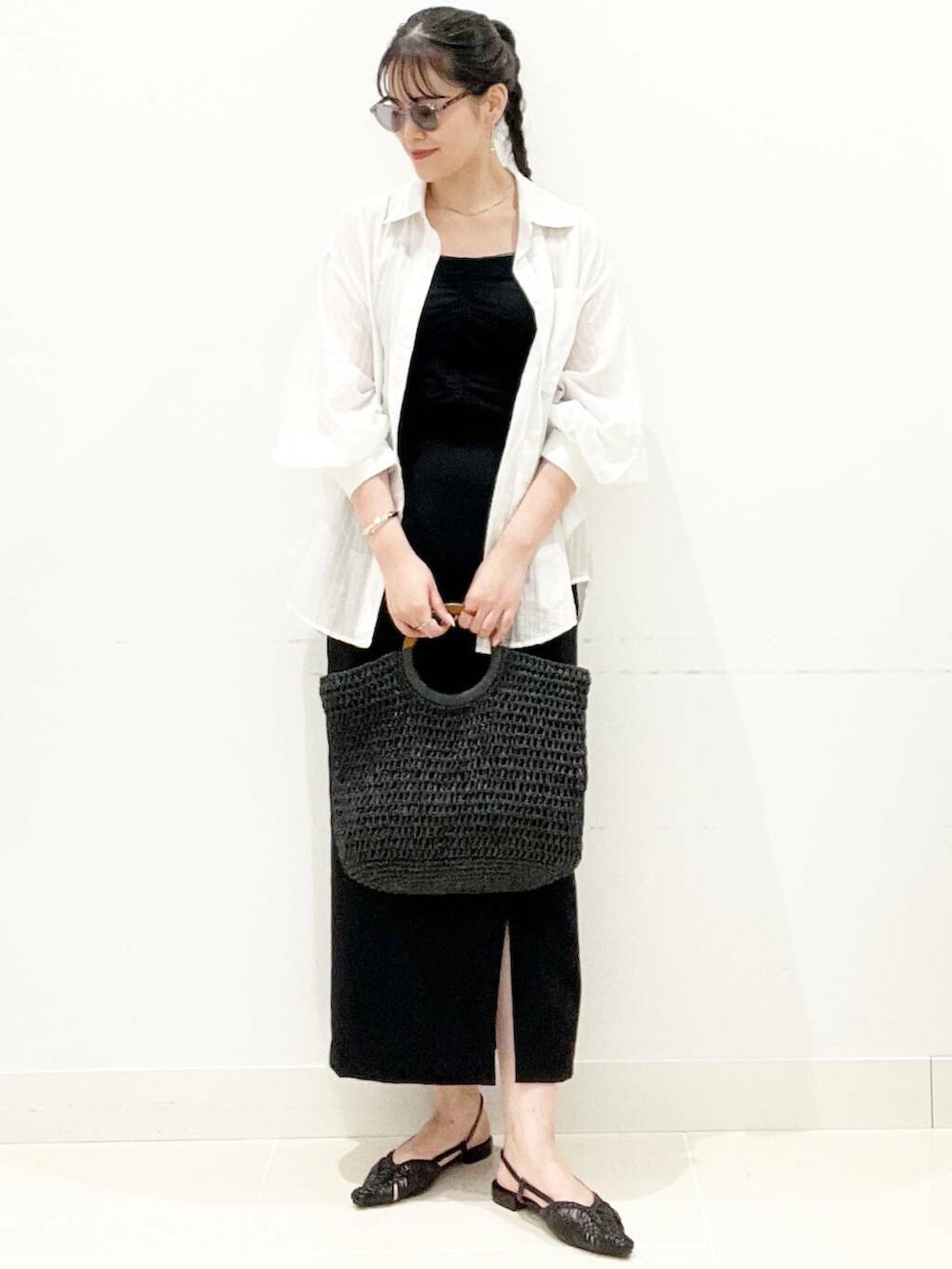 ブラック系のキャミソール、ブラック系のトートバッグ、ブラック系のサンダルを着用したレディースの夏コーディネートの2枚目の写真