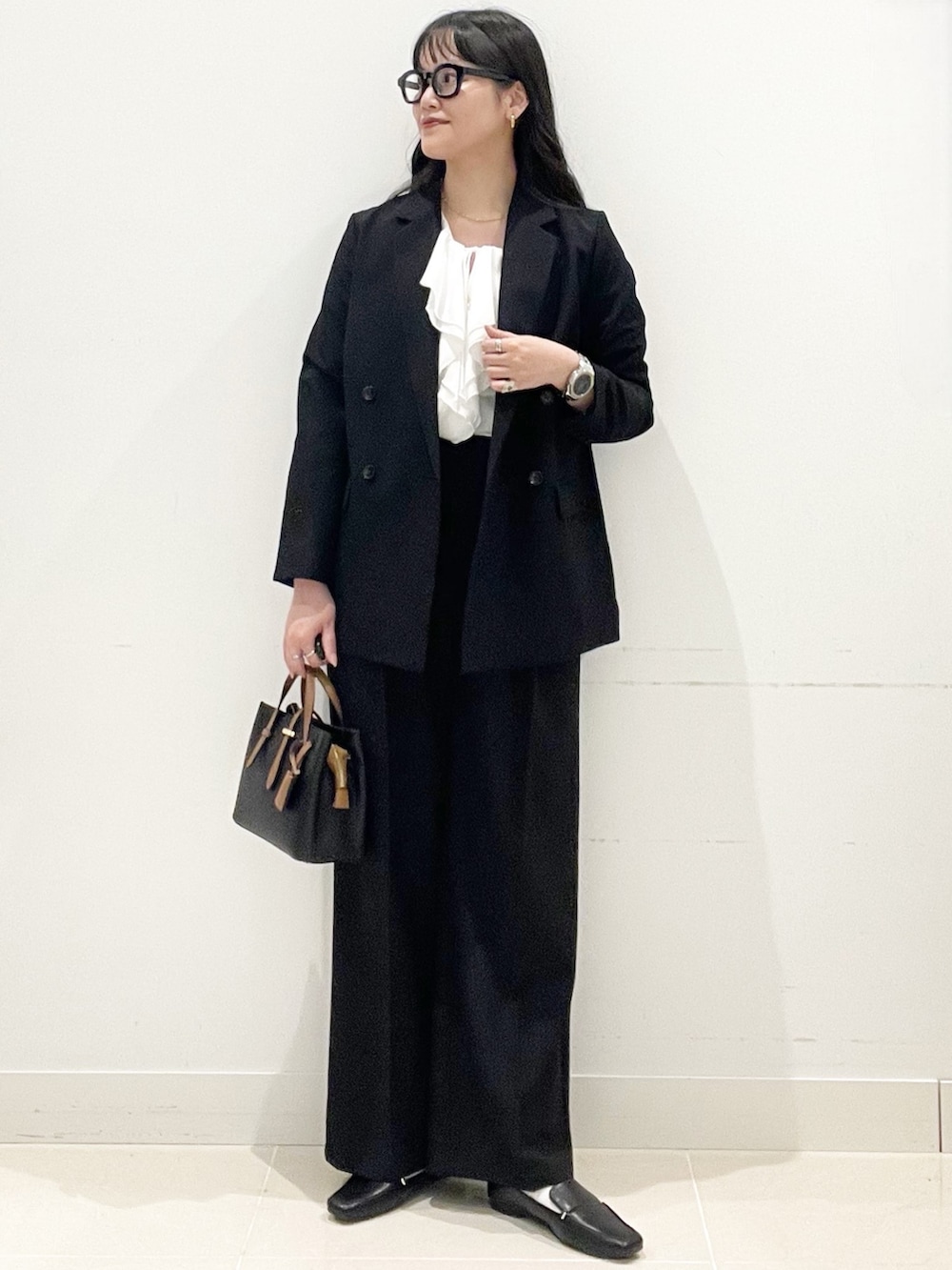 ブラック系のローファー、ブラック系のハンドバッグ、ブラック系のテーラードジャケットを着用したレディースの春コーディネートの3枚目の写真