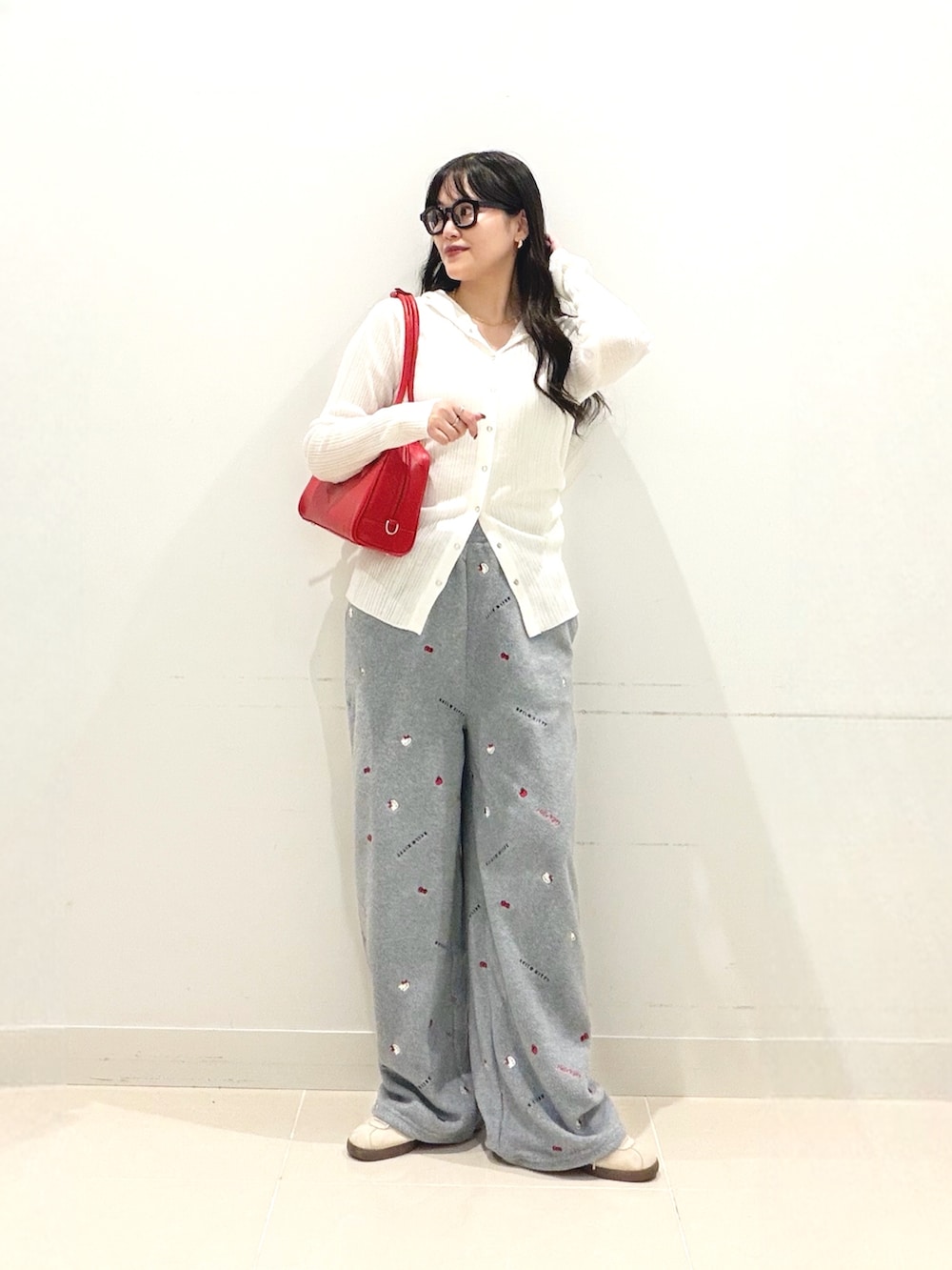 ホワイト系のニット/セーター、グレー系のその他パンツ、レッド系のボストンバッグを着用したレディースの秋コーディネートの3枚目の写真