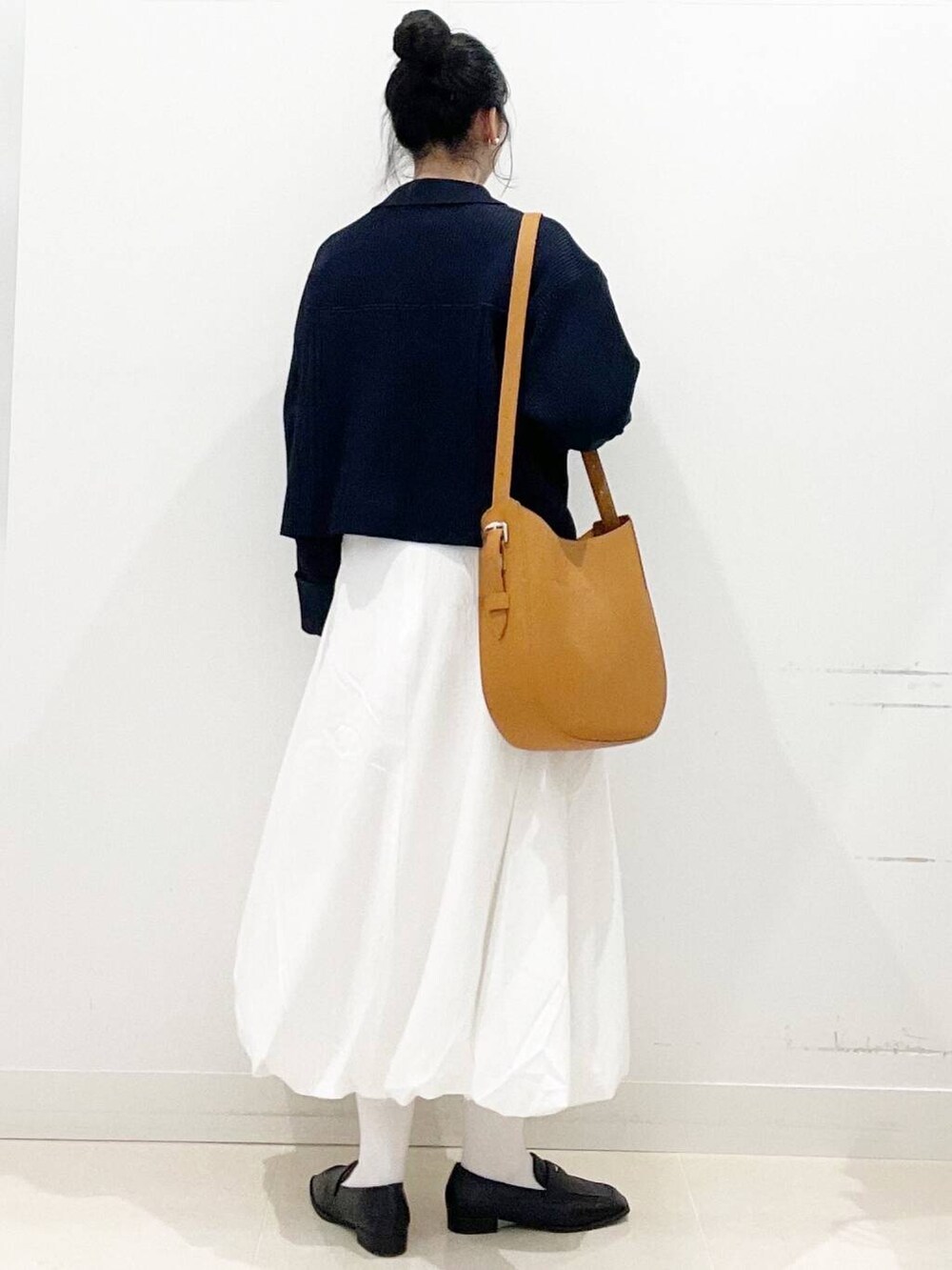 ホワイト系のスカート、ブラウン系のショルダーバッグ、ブラック系のローファーを着用したレディースの冬コーディネートの7枚目の写真