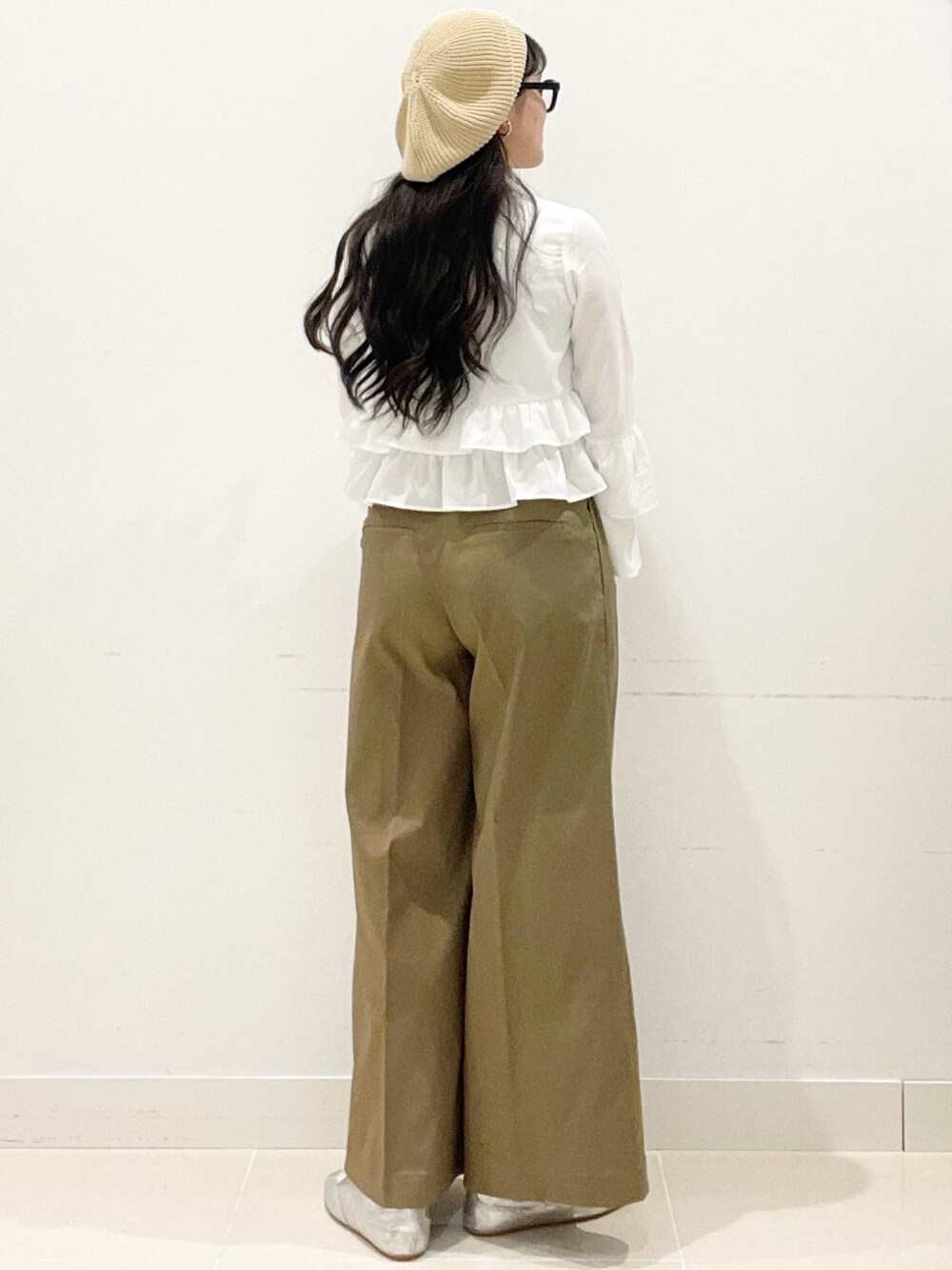 ベージュ系のチノパンツ、ホワイト系のハンドバッグ、ホワイト系のキャミソールを着用したレディースの春コーディネートの6枚目の写真