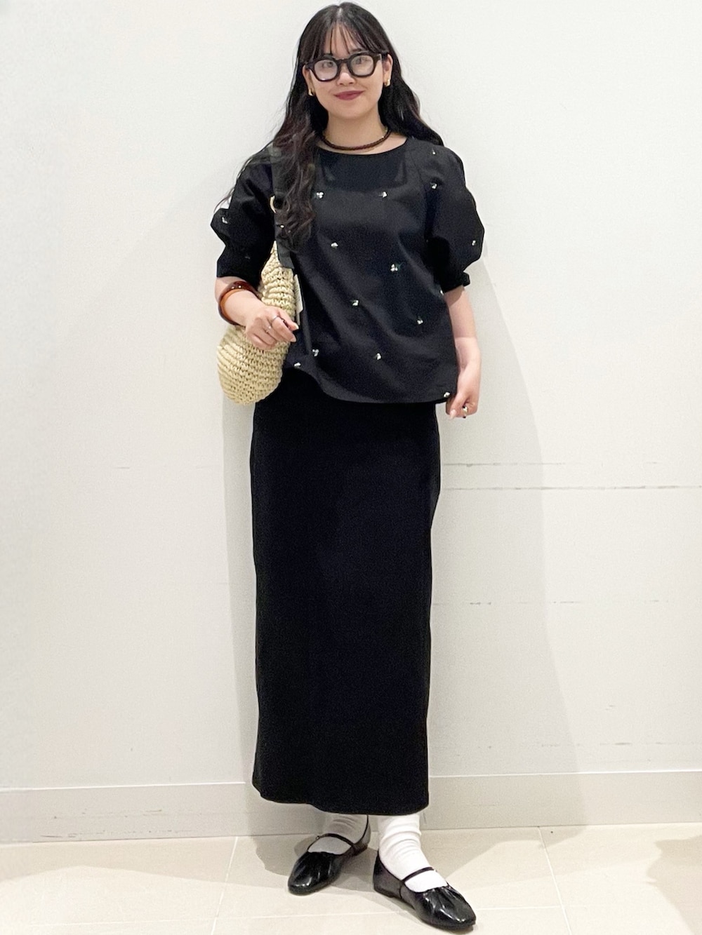 ブラック系のパンプス、ブラック系のスカート、ブラック系のシャツ/ブラウスを着用したレディースの春コーディネートの2枚目の写真