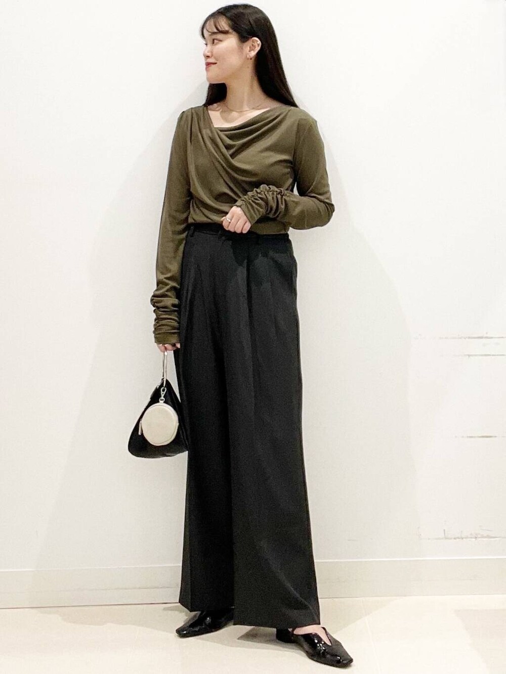 グレー系のその他パンツ、ブラック系のパンプス、ブラック系のハンドバッグを着用したレディースの春コーディネートの3枚目の写真