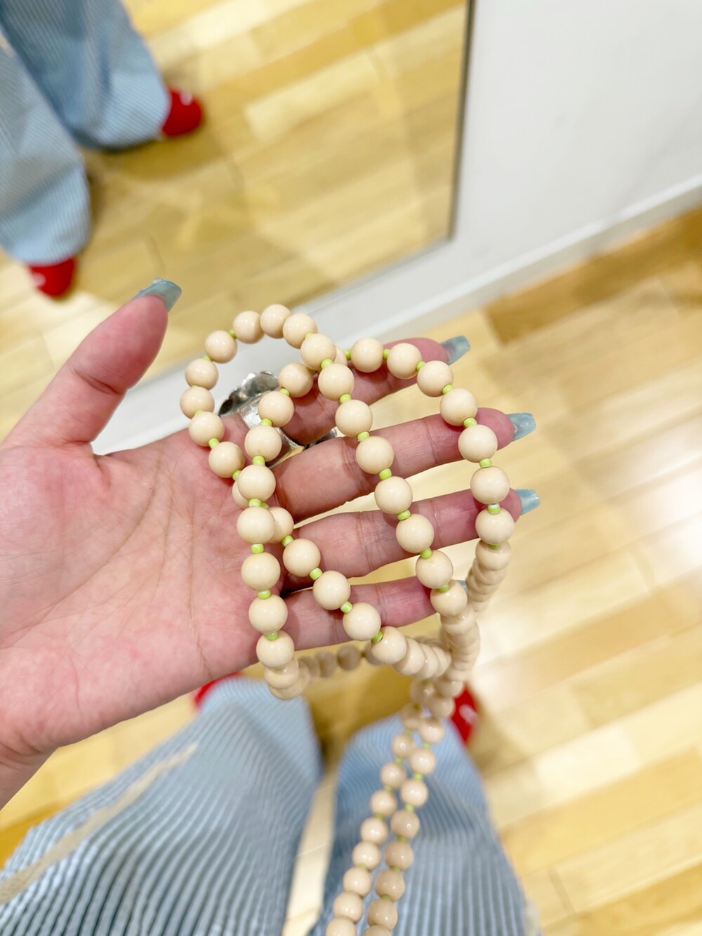 レッド系のスニーカー、ブルー系のその他パンツ、ベージュ系のスマホグッズを着用したレディースの夏コーディネートの3枚目の写真
