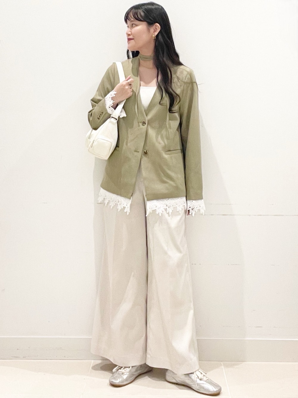 ホワイト系のチノパンツ、ベージュ系のノーカラージャケット、ホワイト系のショルダーバッグを着用したレディースの春コーディネートの5枚目の写真