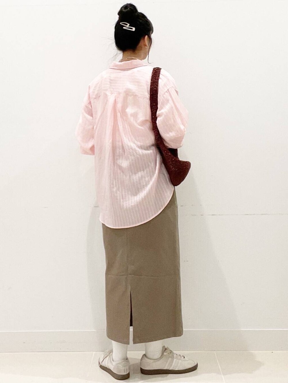 ホワイト系のスニーカー、ブラウン系のスカート、ホワイト系のキャミソールを着用したレディースの春コーディネートの7枚目の写真