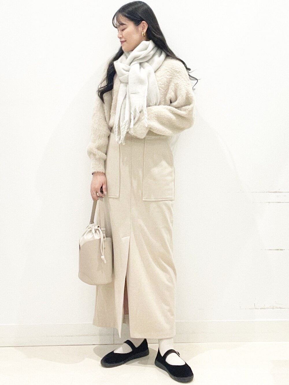 ブラック系のその他シューズ、ベージュ系のスカート、ベージュ系のハンドバッグを着用したレディースの秋コーディネートの6枚目の写真