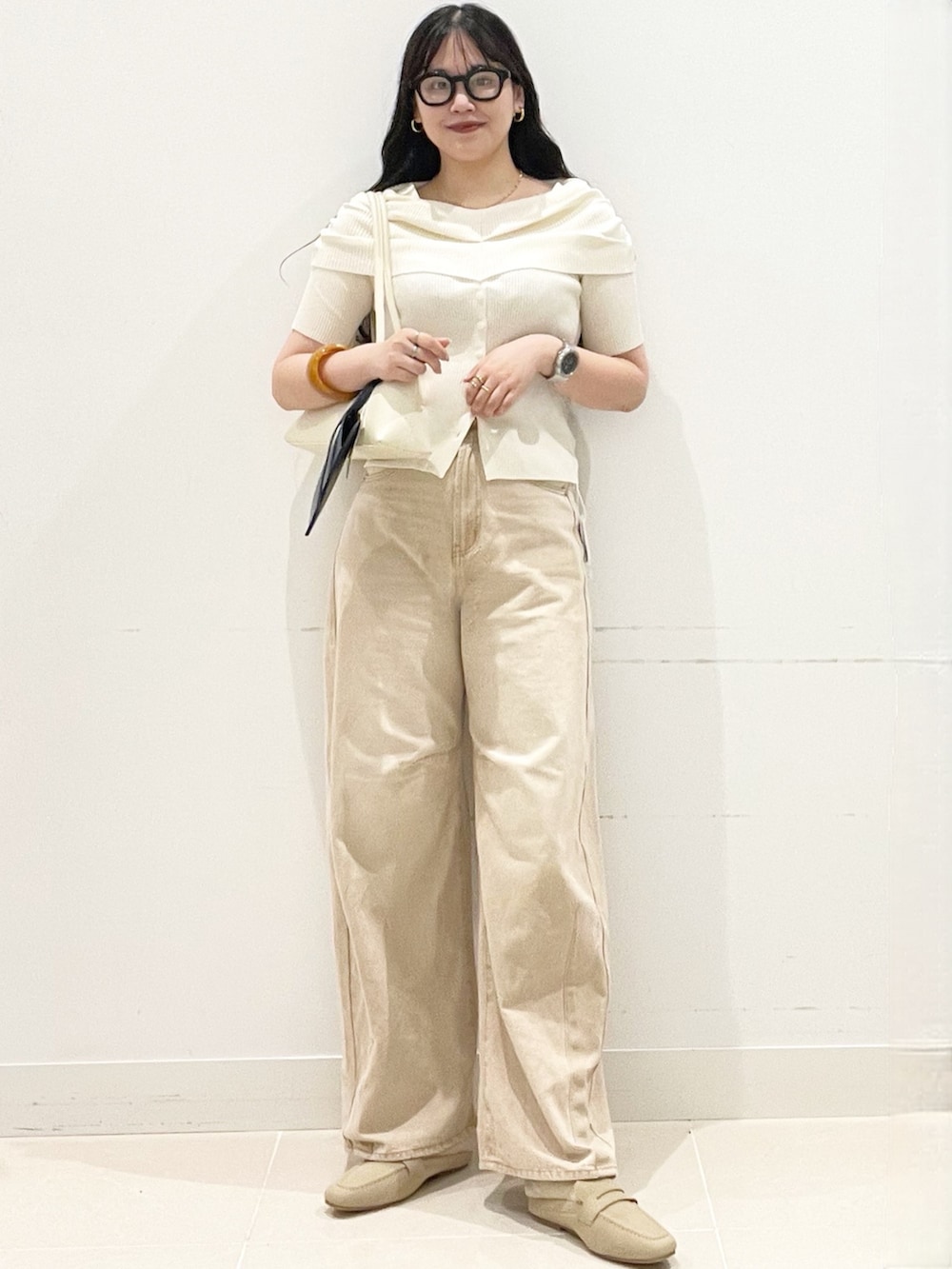 ベージュ系のローファー、ベージュ系のデニムパンツ、ホワイト系のニット/セーターを着用したレディースの春コーディネートの2枚目の写真