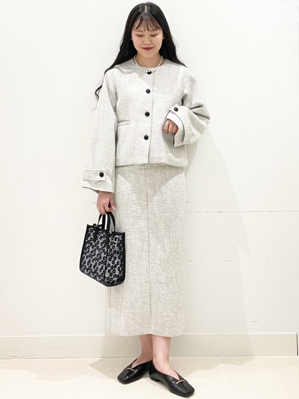 ホワイト系のスカート、ブラック系のその他シューズ、ブラック系のハンドバッグを着用したレディースの冬コーディネートの2枚目の写真
