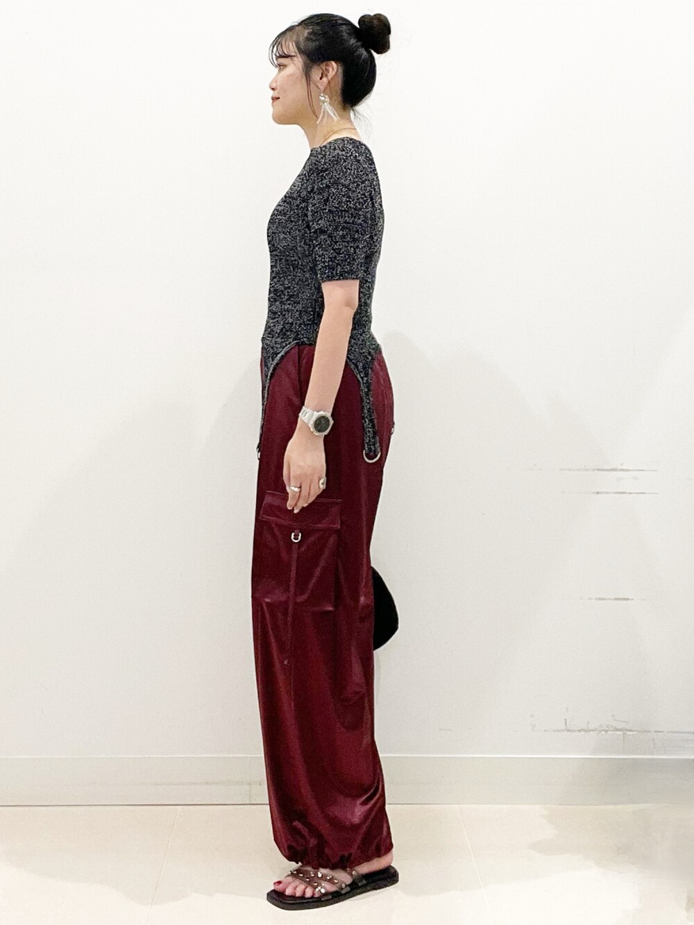 ブラック系のサンダル、ブラック系のハンドバッグ、レッド系のカーゴパンツを着用したレディースの夏コーディネートの5枚目の写真