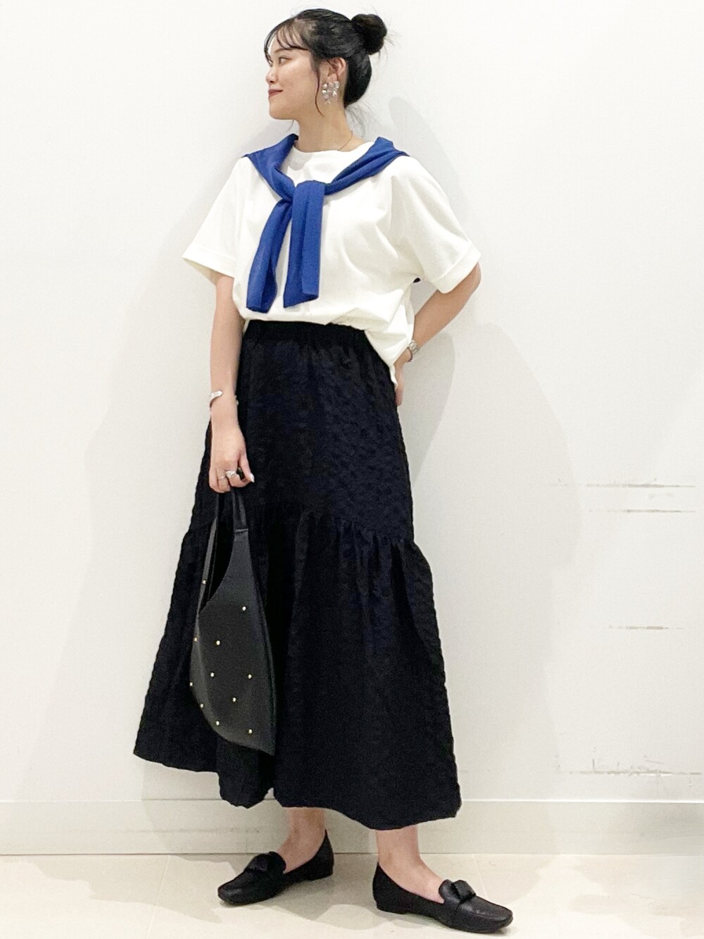 ブラック系のドレスシューズ、ブラック系のスカート、ホワイト系のTシャツ/カットソーを着用したレディースの夏コーディネートの2枚目の写真