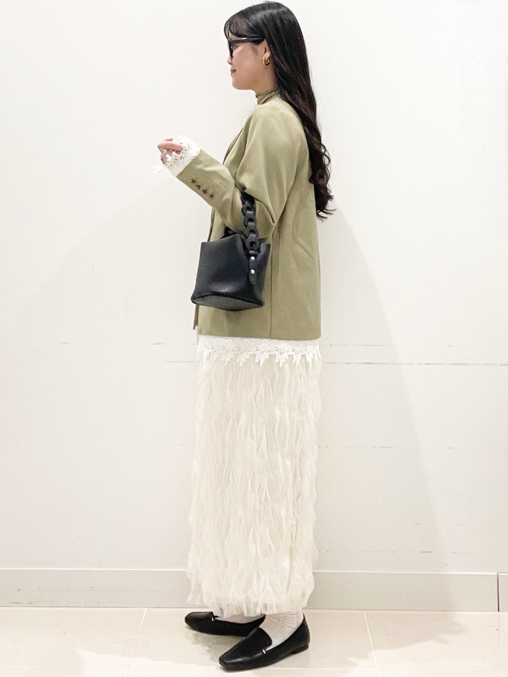 ブラック系のローファー、ホワイト系のスカート、ベージュ系のノーカラージャケットを着用したレディースの春コーディネートの5枚目の写真