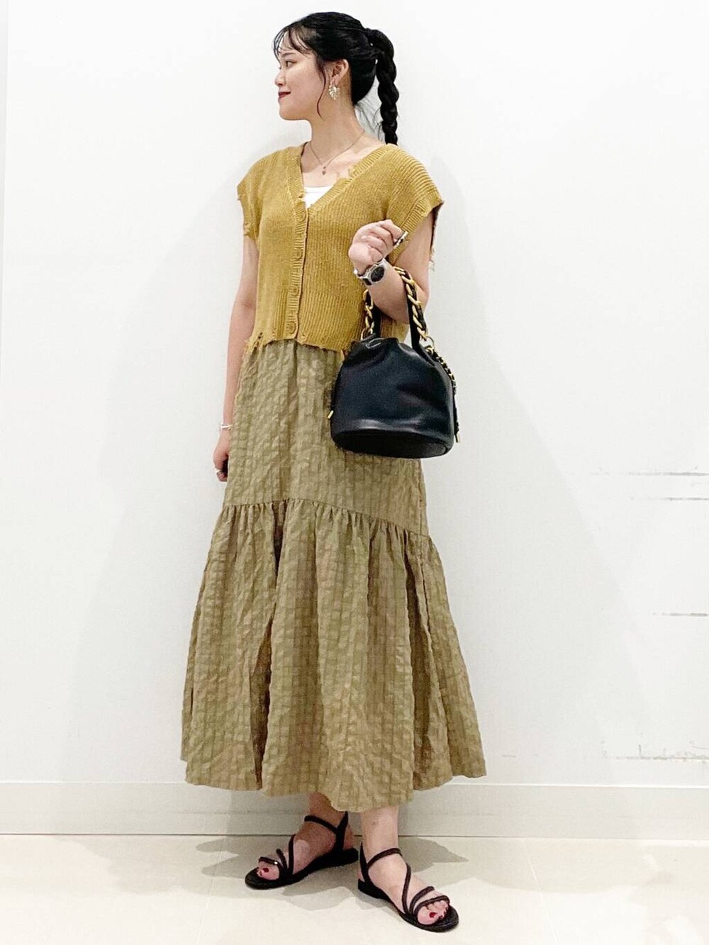 ホワイト系のキャミソール、グリーン系のスカート、ブラック系のサンダルを着用したレディースの夏コーディネートの4枚目の写真