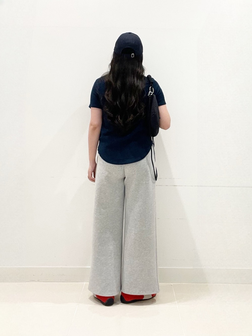 ホワイト系のキャミソール、グレー系のその他パンツ、レッド系のスニーカーを着用したレディースの夏コーディネートの5枚目の写真