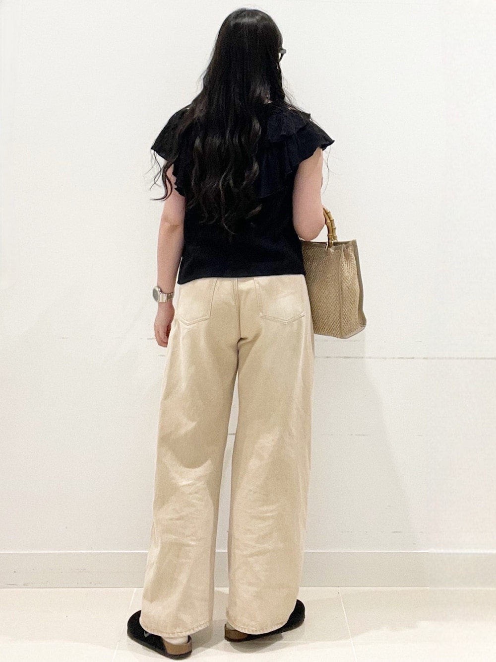 ブラック系のシャツ/ブラウス、ベージュ系のデニムパンツ、ベージュ系のショルダーバッグを着用したレディースの春コーディネートの4枚目の写真