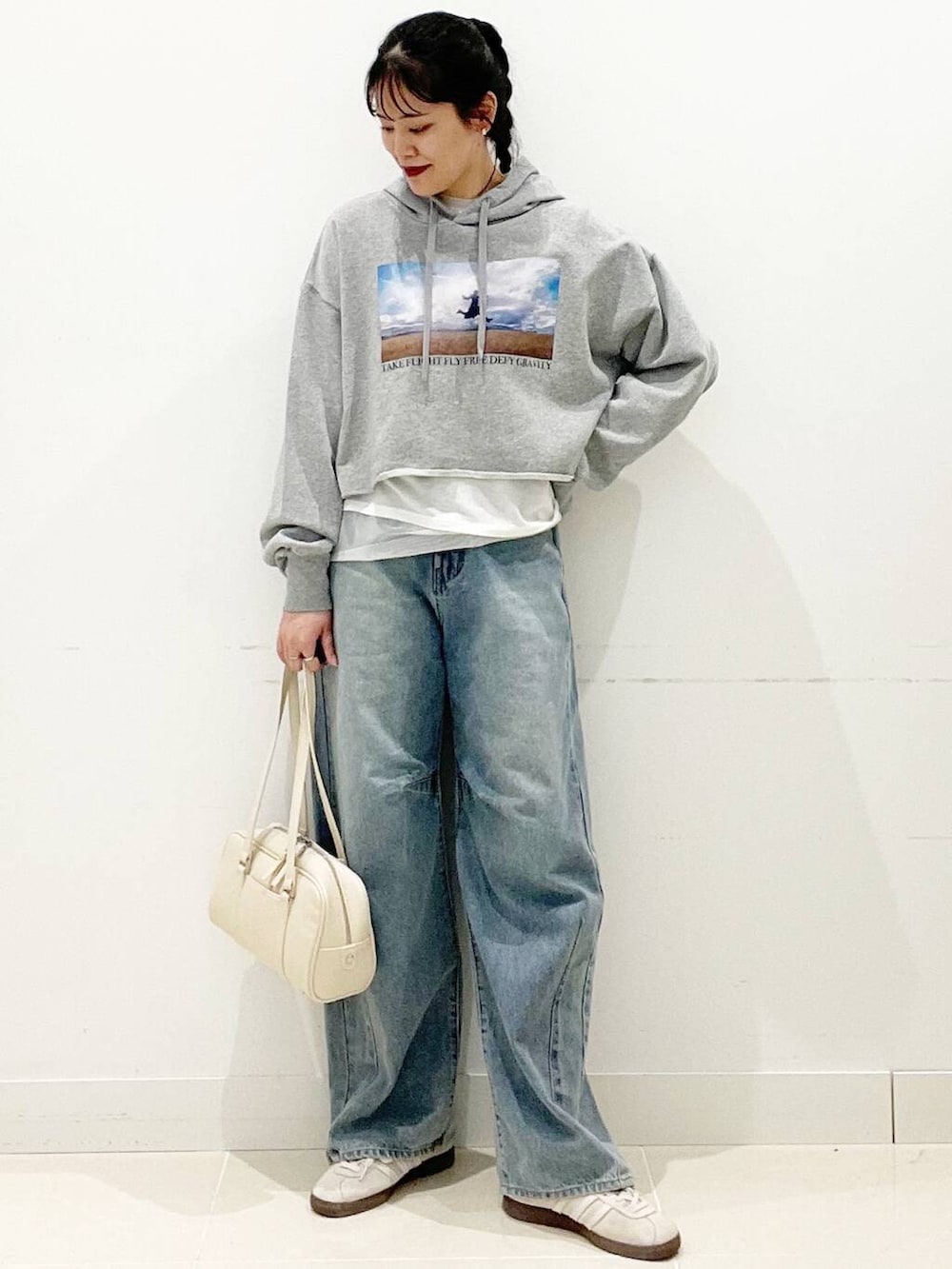 ホワイト系のスニーカー、ホワイト系のTシャツ/カットソー、ホワイト系のボストンバッグを着用したレディースの春コーディネートの2枚目の写真