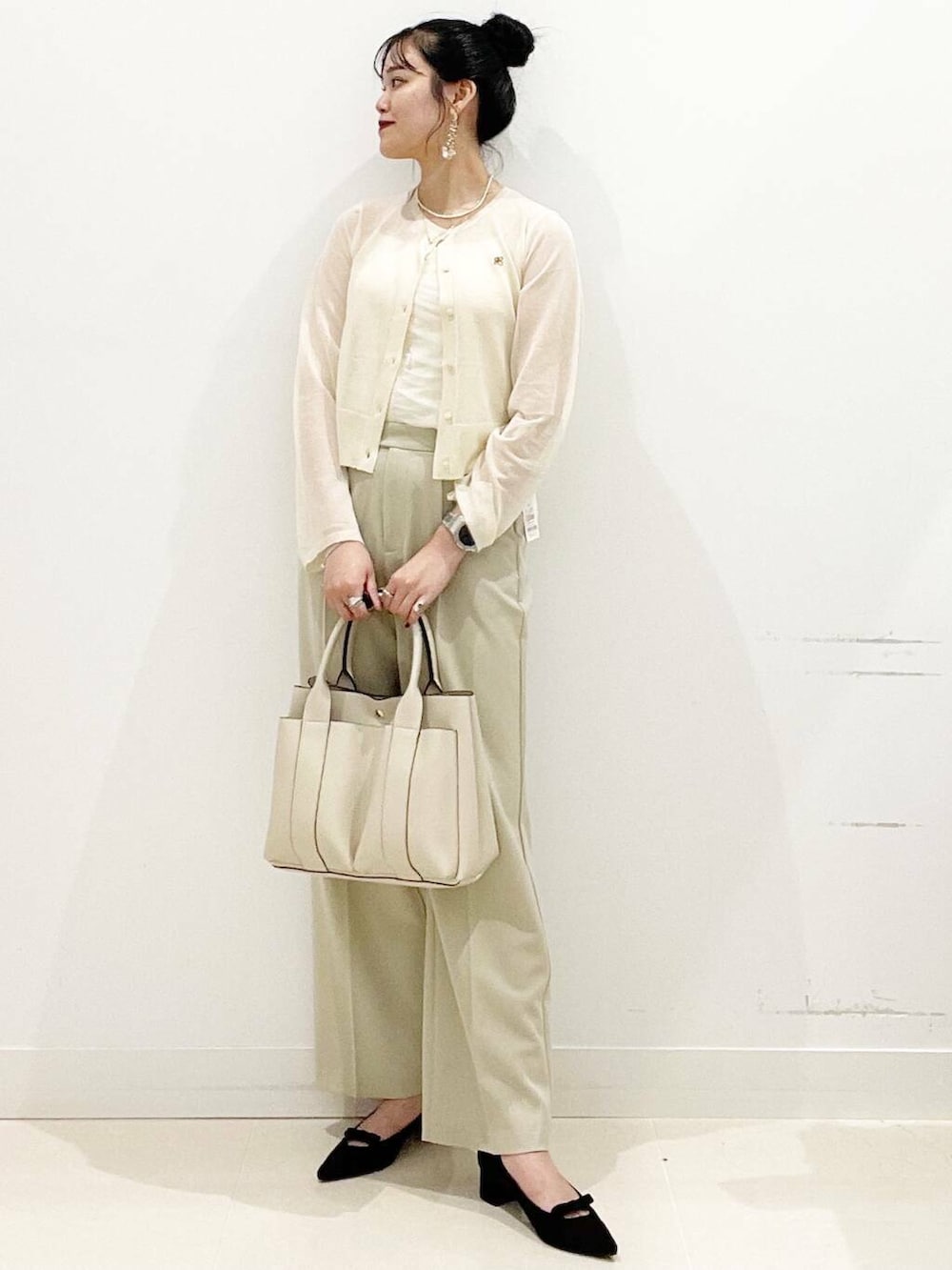 ホワイト系のトートバッグ、ホワイト系のキャミソール、ベージュ系のその他パンツを着用したレディースの秋コーディネートの3枚目の写真