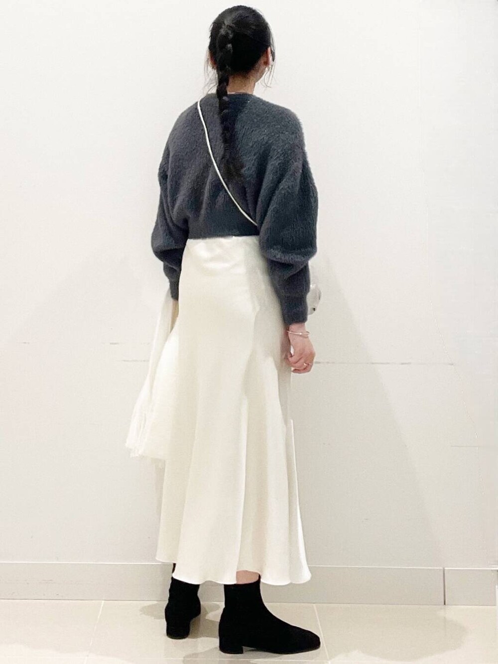 グレー系のニット/セーター、ブラック系のブーツ、シルバー系のショルダーバッグを着用したレディースの冬コーディネートの7枚目の写真