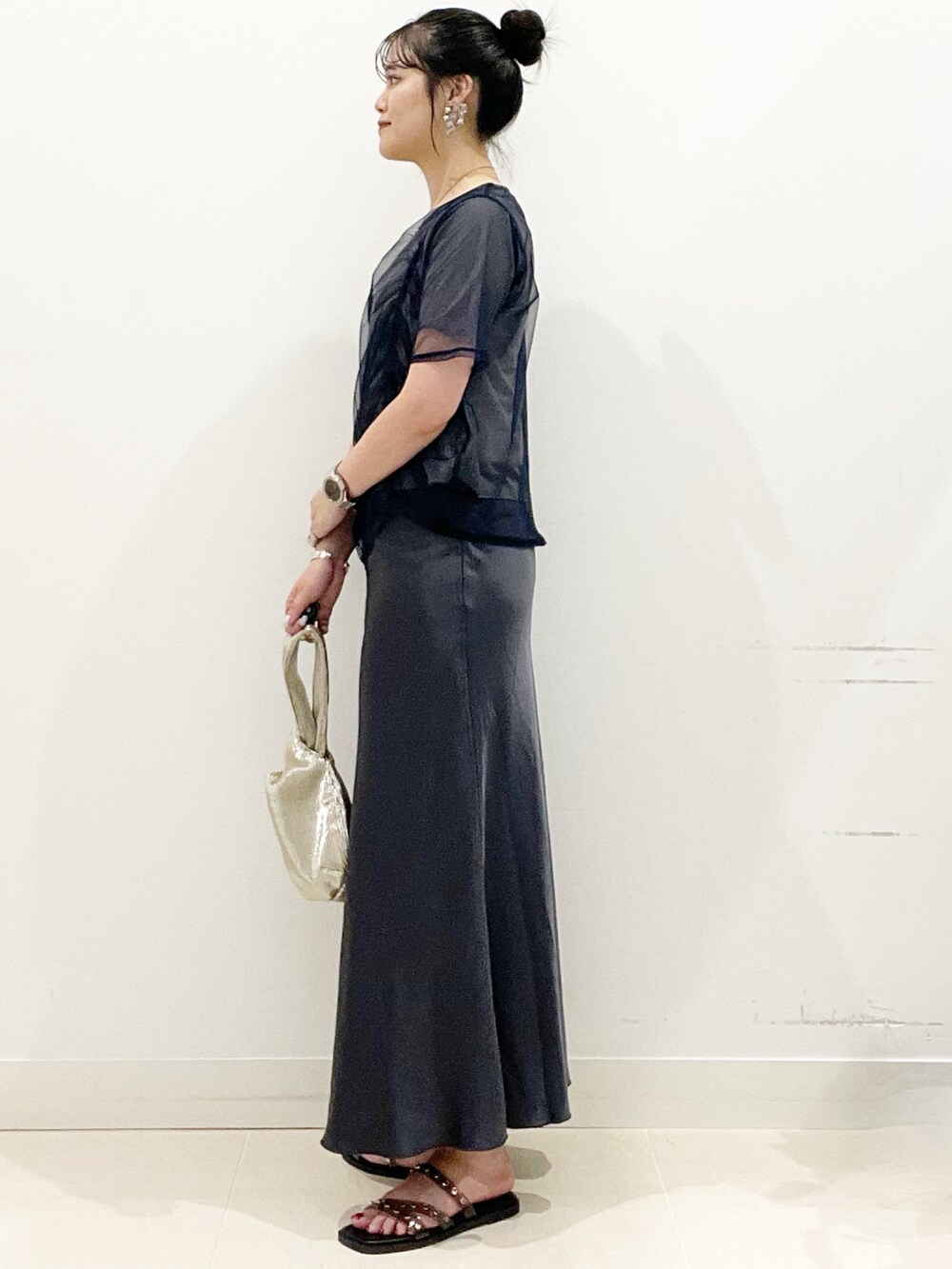 ブラック系のサンダル、ゴールド系のハンドバッグ、ブルー系のTシャツ/カットソーを着用したレディースの夏コーディネートの5枚目の写真