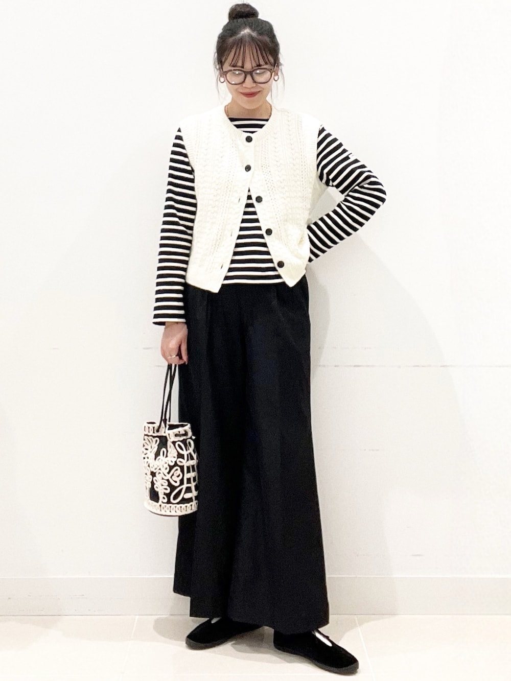 ブラック系のその他シューズ、ブラック系のその他パンツ、ブラック系のハンドバッグを着用したレディースの秋コーディネートの4枚目の写真