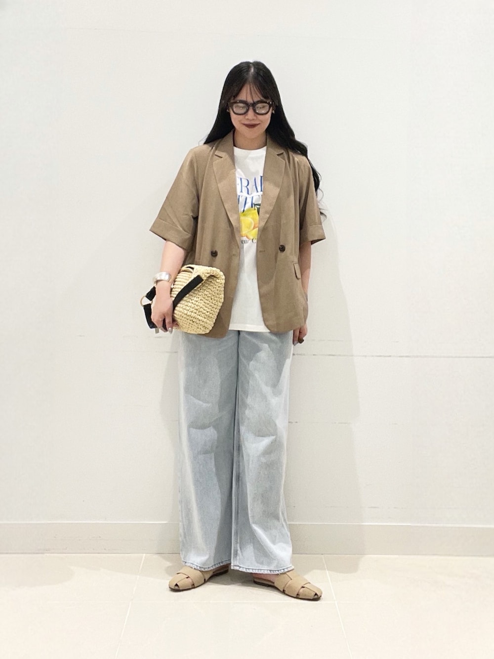 ベージュ系のテーラードジャケット、ホワイト系のTシャツ/カットソー、ブルー系のデニムパンツを着用したレディースの夏コーディネートの3枚目の写真