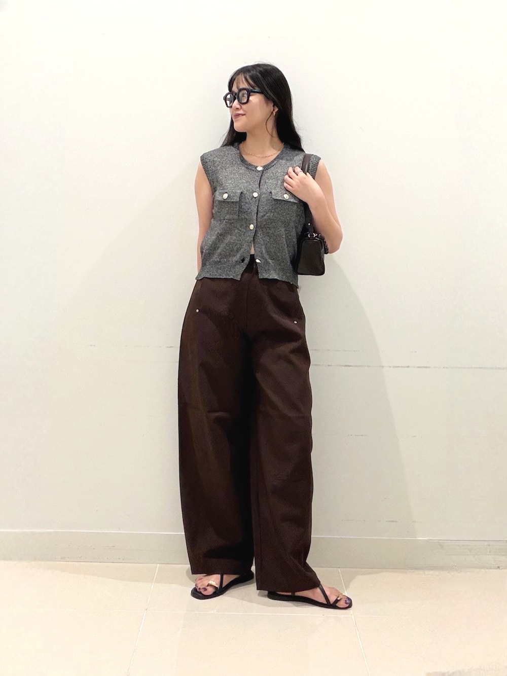 ブラック系のベスト、ブラウン系のその他パンツ、ブラウン系のショルダーバッグを着用したレディースの秋コーディネートの3枚目の写真