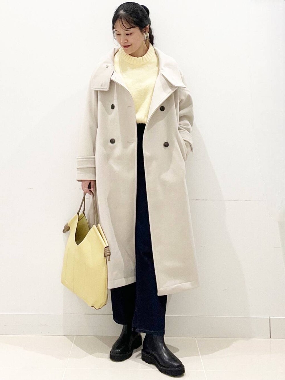 ブラック系のブーツ、ベージュ系のその他アウター、ブルー系のデニムパンツを着用したレディースの冬コーディネートの5枚目の写真