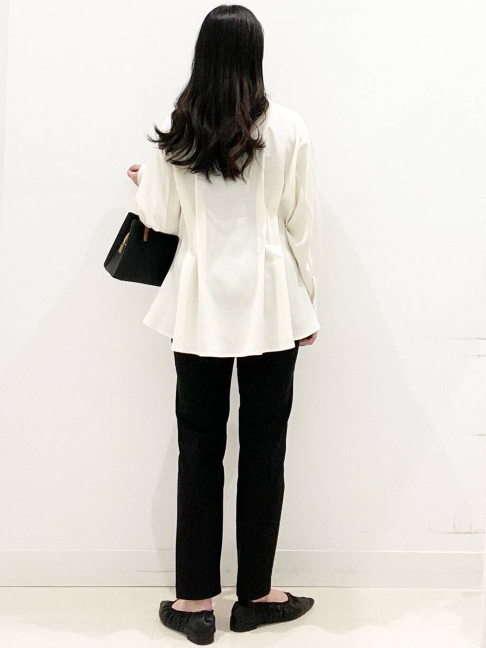 ブラック系のハンドバッグ、ブラック系のバレエシューズ、ホワイト系のシャツ/ブラウスを着用したレディースの冬コーディネートの4枚目の写真
