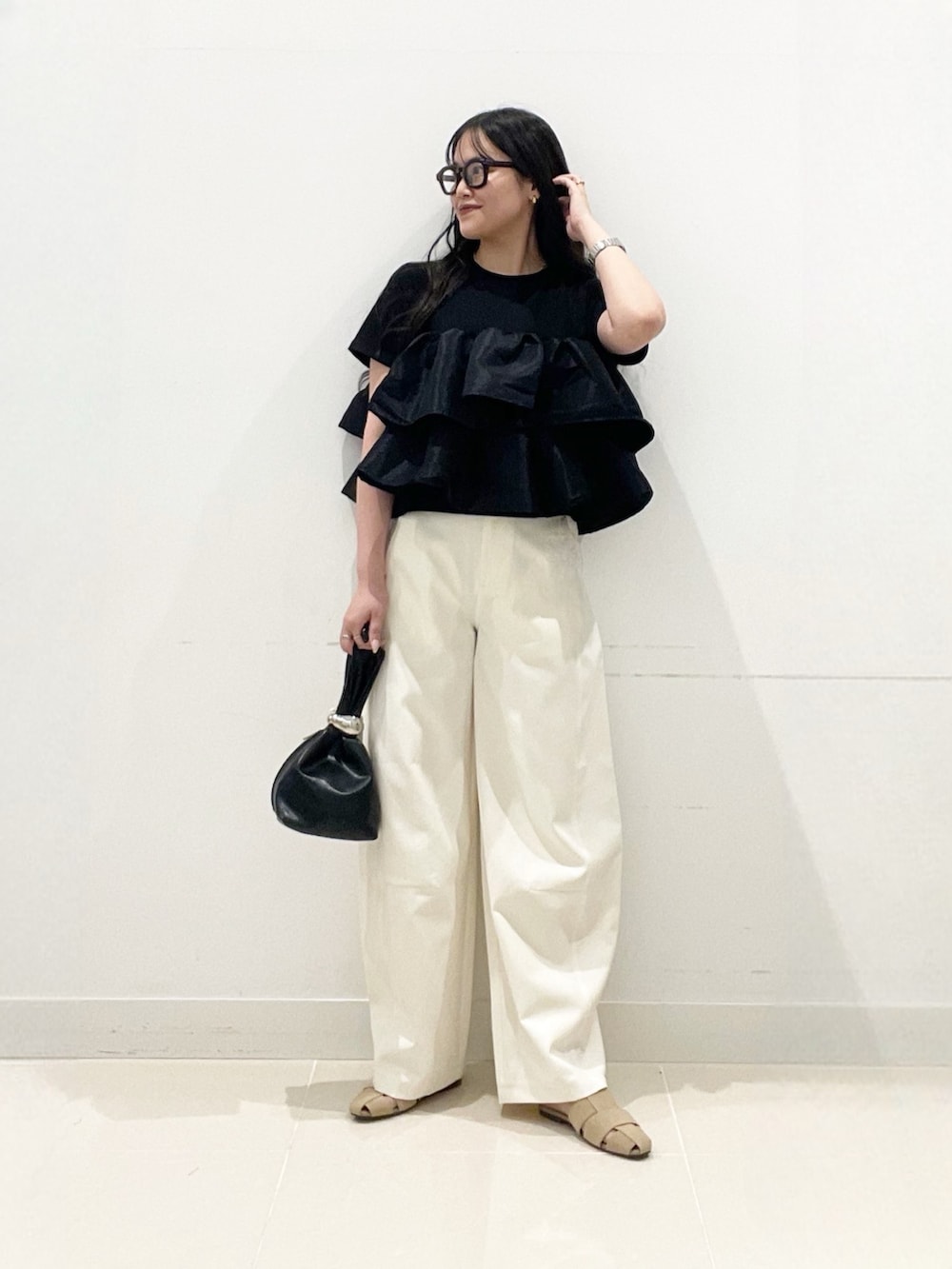 ブラック系のTシャツ/カットソー、ブラック系のハンドバッグ、ホワイト系のその他パンツを着用したレディースの夏コーディネートの6枚目の写真