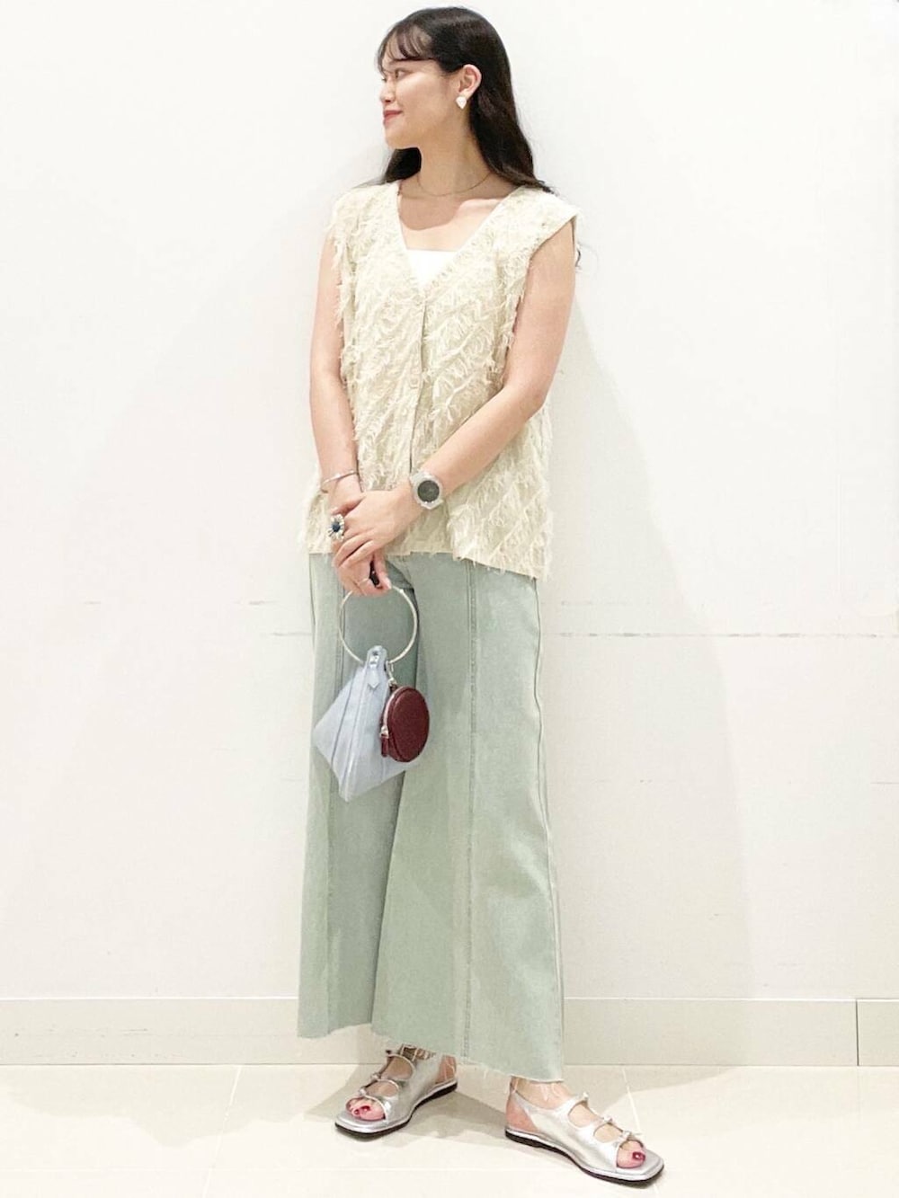 ブルー系のハンドバッグ、ホワイト系のキャミソール、シルバー系のサンダルを着用したレディースの夏コーディネートの3枚目の写真
