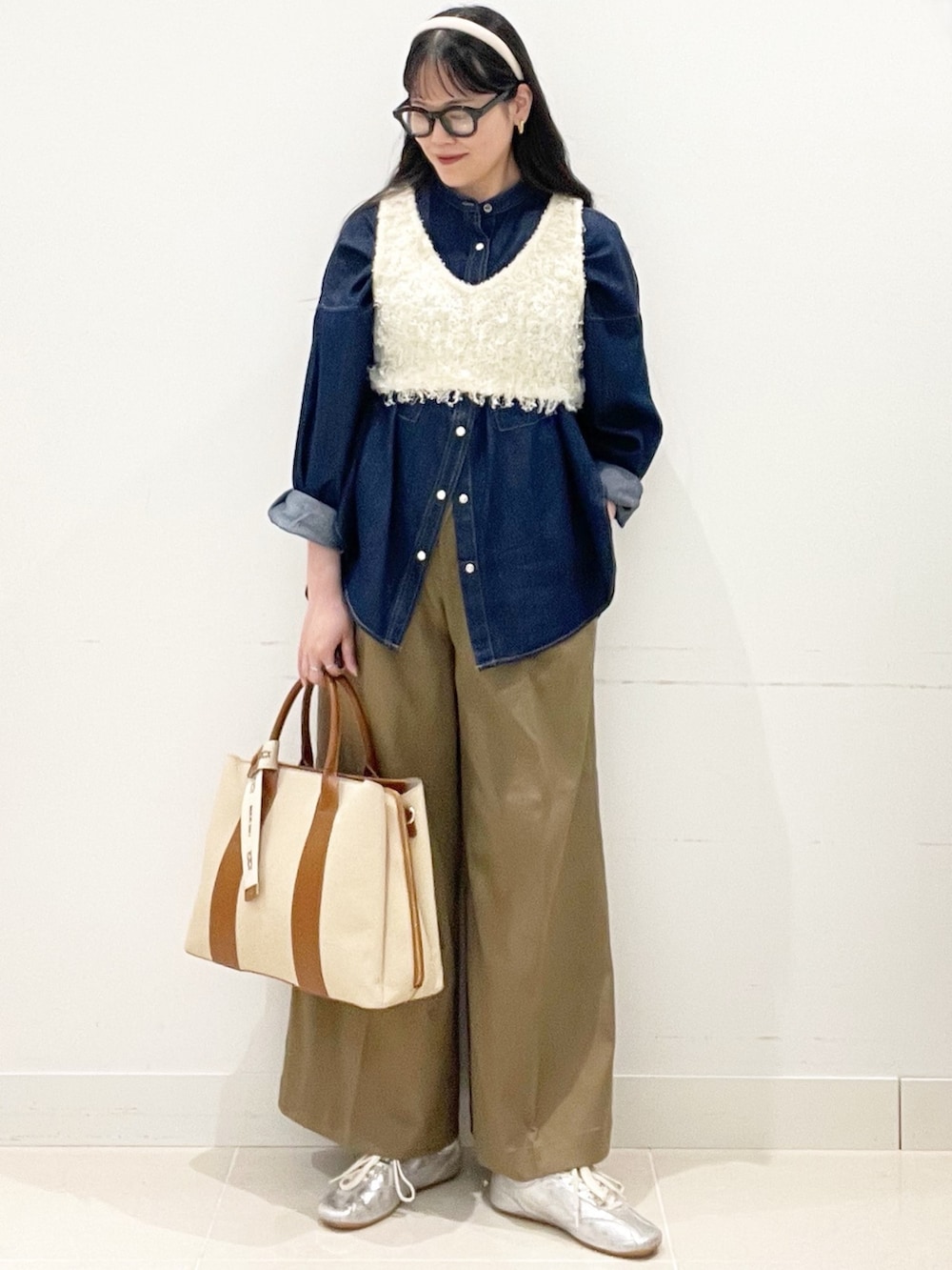ベージュ系のチノパンツ、ホワイト系のトートバッグ、ブルー系のシャツ/ブラウスを着用したレディースの春コーディネートの3枚目の写真