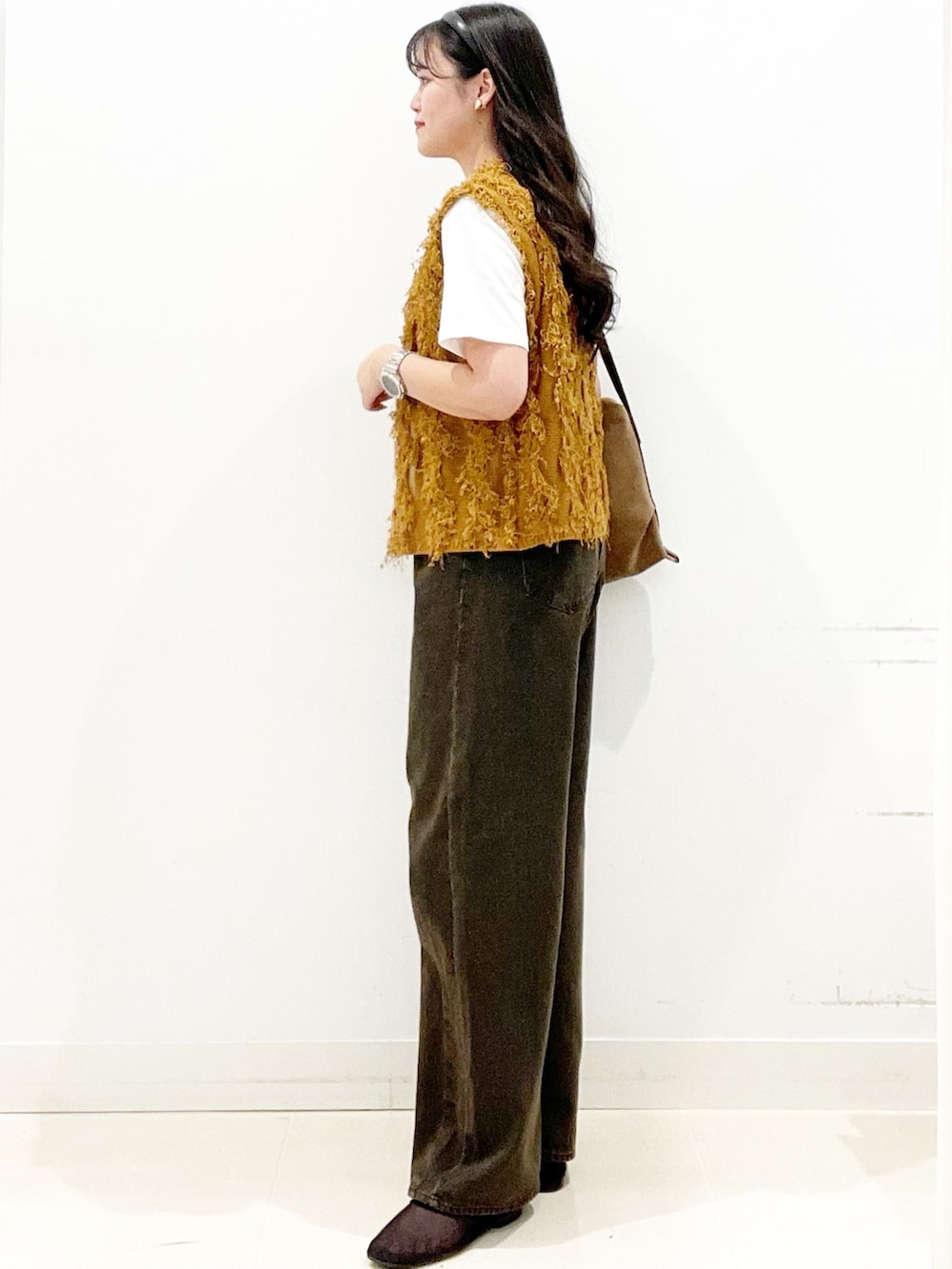 ブラック系のバレエシューズ、ブラウン系のデニムパンツ、ブラウン系のショルダーバッグを着用したレディースの秋コーディネートの4枚目の写真