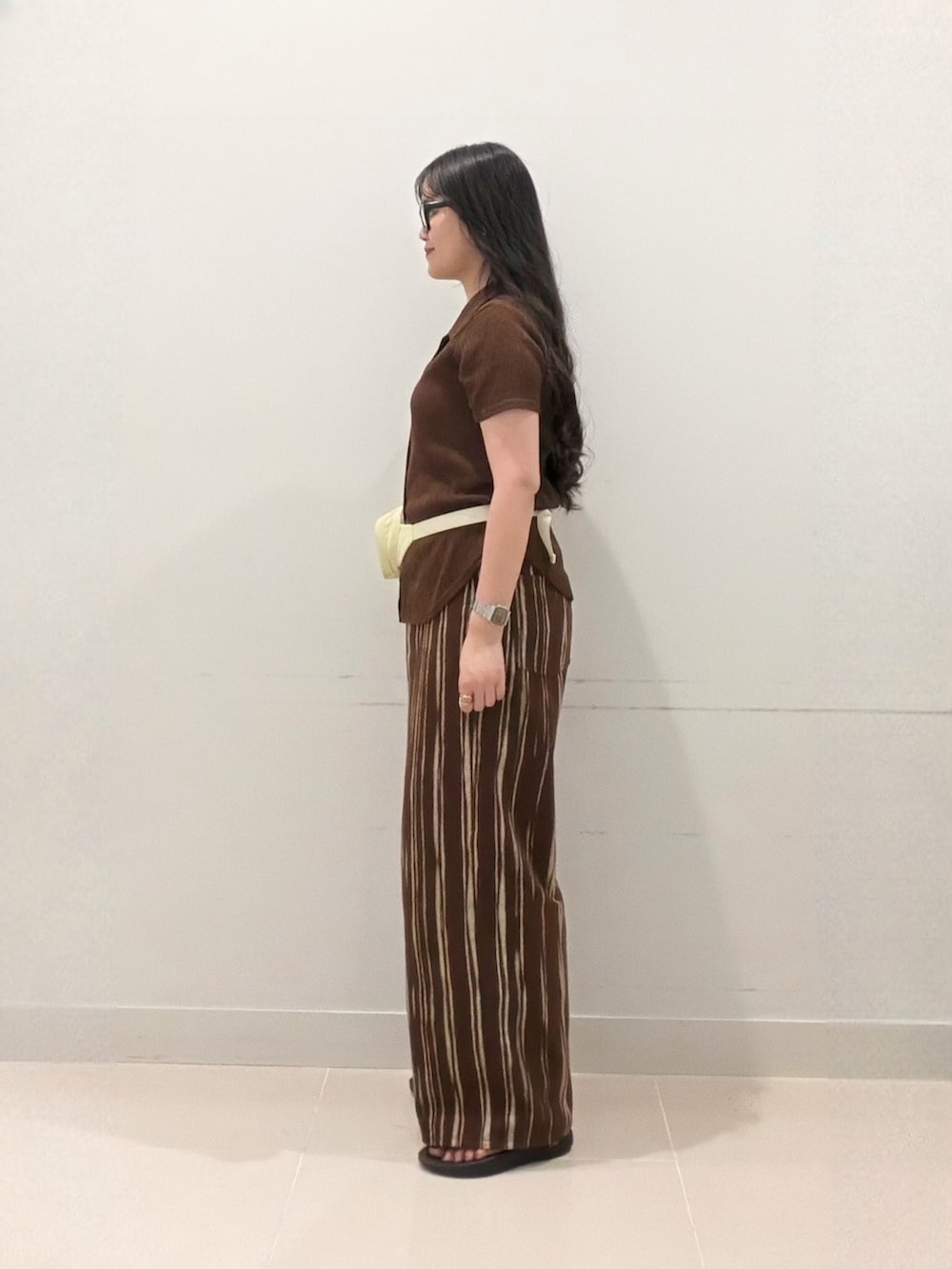 ブラウン系のシャツ/ブラウス、ホワイト系のキャミソール、ブラウン系のデニムパンツを着用したレディースの夏コーディネートの5枚目の写真