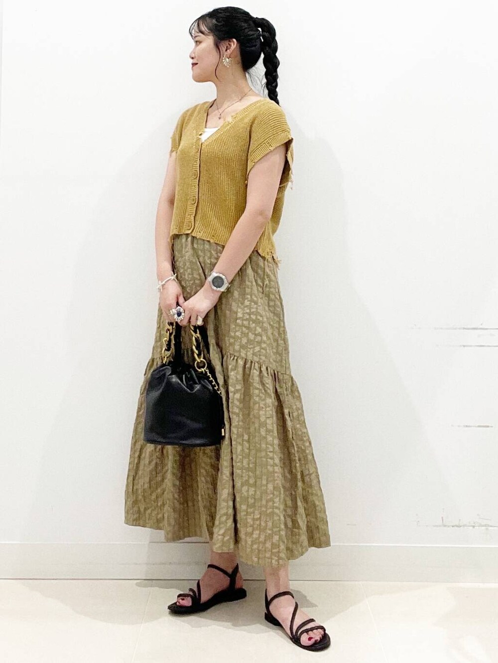 ホワイト系のキャミソール、グリーン系のスカート、ブラック系のサンダルを着用したレディースの夏コーディネートの2枚目の写真