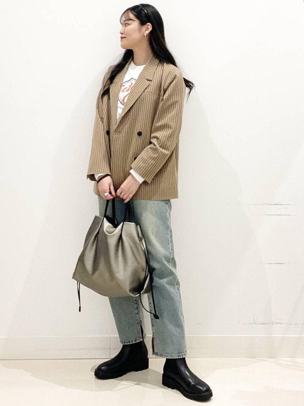 シルバー系のトートバッグ、ブルー系のその他パンツ、ブラック系のブーツを着用したレディースの秋コーディネートの5枚目の写真