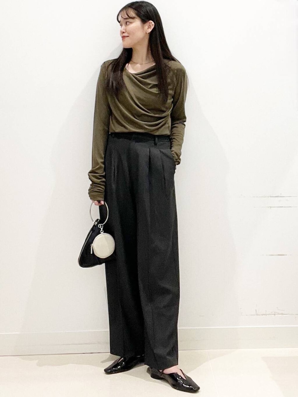 グレー系のその他パンツ、ブラック系のパンプス、ブラック系のハンドバッグを着用したレディースの春コーディネートの4枚目の写真