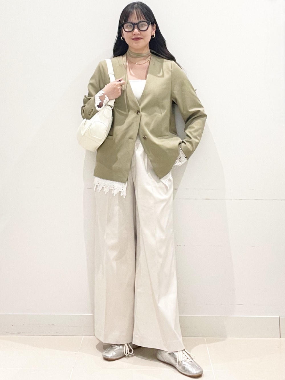 ホワイト系のチノパンツ、ベージュ系のノーカラージャケット、ホワイト系のショルダーバッグを着用したレディースの春コーディネートの2枚目の写真