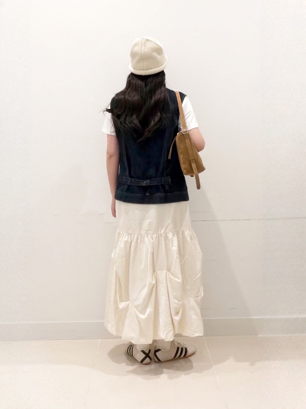 ホワイト系のTシャツ/カットソー、ブルー系のベスト、イエロー系のショルダーバッグを着用したレディースの秋コーディネートの4枚目の写真
