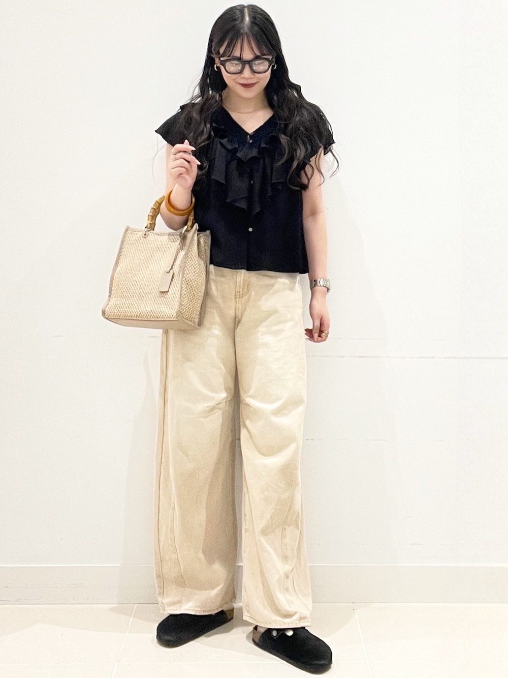 ブラック系のシャツ/ブラウス、ベージュ系のデニムパンツ、ベージュ系のショルダーバッグを着用したレディースの春コーディネートの3枚目の写真